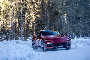 Vista lateral del Ferrari Purosangue rodando en un entorno nevado.