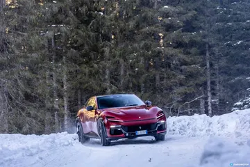 Vista lateral de Ferrari Purosangue resaltando su diseño en paisaje invernal