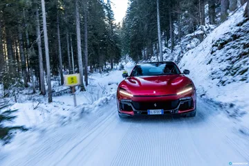 Vista trasera Ferrari Purosangue en carretera nevada.