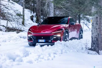 Ferrari Purosangue surcando la nieve, vista delantera y lateral.