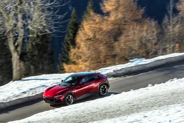 Vista lateral del Ferrari Purosangue en un paisaje nevado