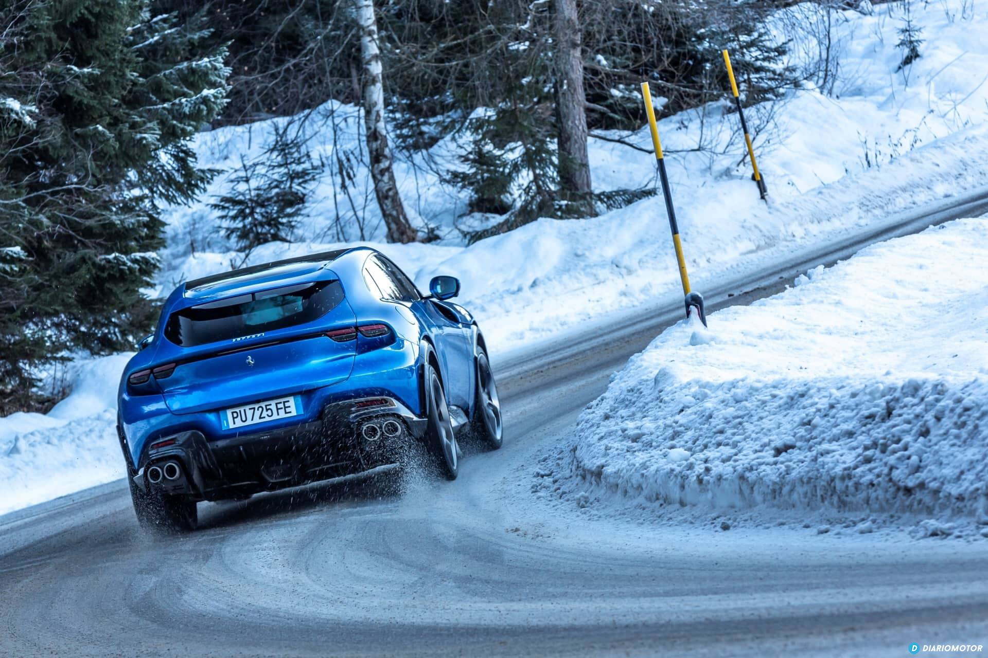 Vista lateral de un Ferrari Purosangue avanzando sobre una carretera nevada.