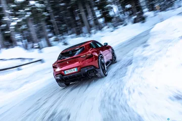 Ferrari Purosangue deslizándose con destreza en una pista nevada.