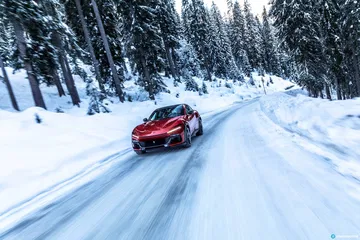 Vista lateral del Ferrari Purosangue sortenado con elegancia las condiciones invernales.