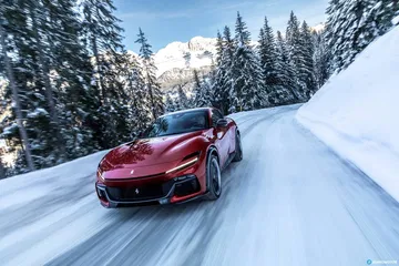 Vista frontal y lateral del Ferrari Purosangue en un paisaje nevado.