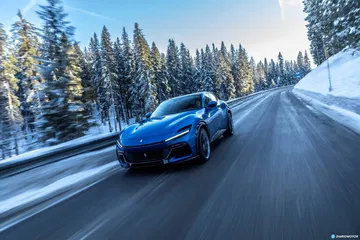 Vista lateral del Ferrari Purosangue desplazándose ágilmente en un entorno invernal.