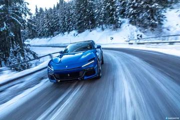 Vista lateral del Ferrari Purosangue en carretera invernal