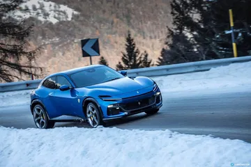 Perfil del Ferrari Purosangue destacando su diseño lateral sobre nieve.