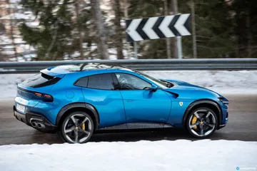 Ferrari Purosangue en perfil, sobre fondo nevado resaltando su diseño lateral.