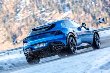 Vista lateral del Ferrari Purosangue deslizándose sobre la nieve.