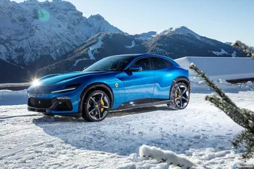 Perfil lateral del Ferrari Purosangue en un paisaje nevado, destacando su línea deportiva.