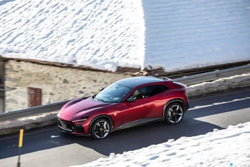 Vista lateral del Ferrari Purosangue en color rojo estacionado.