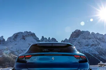 Vista trasera del Ferrari Purosangue con montañas nevadas de fondo.