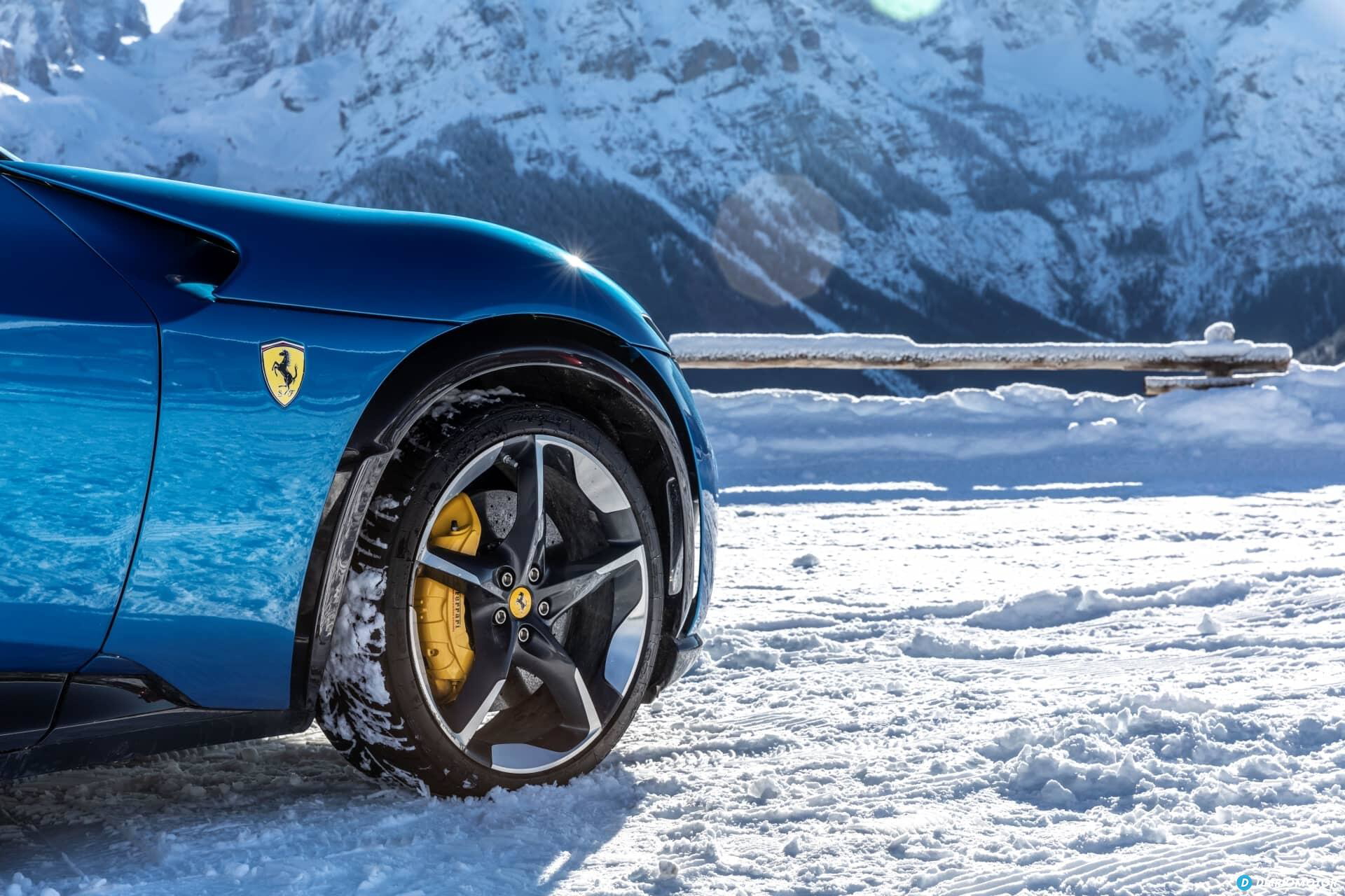 Vista lateral de la rueda del Ferrari Purosangue con pinzas de freno amarillas en un paisaje nevado.