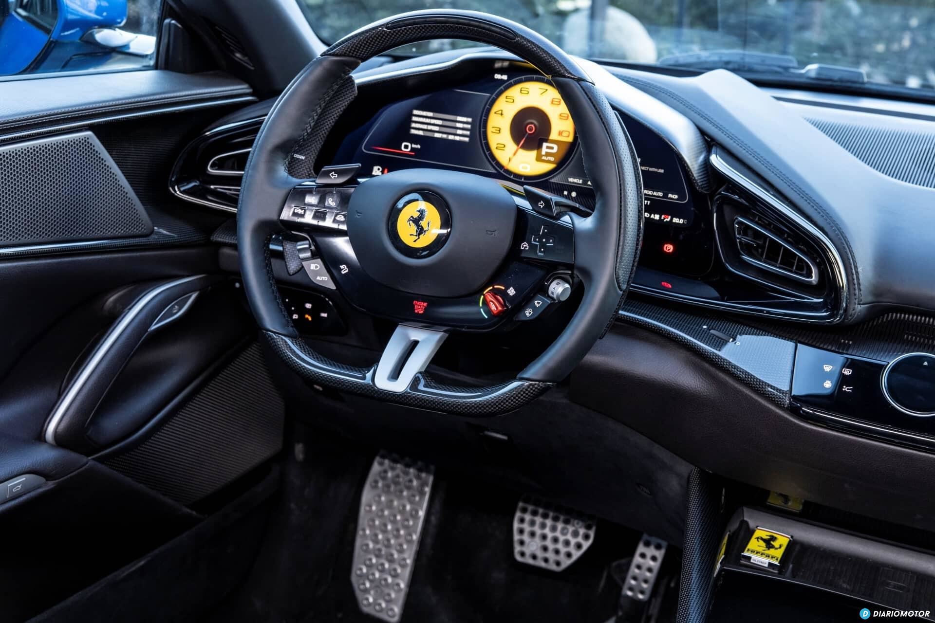 Volante multifunción con emblema Ferrari al centro.