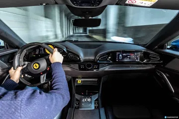 Vista del volante y pantalla central del Ferrari Purosangue, detalles de alta tecnología.