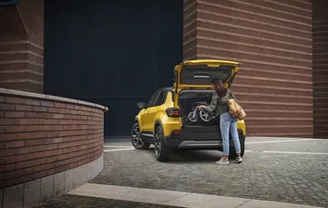Vista de tres cuartos trasera del Jeep Avenger iluminado en ambiente urbano