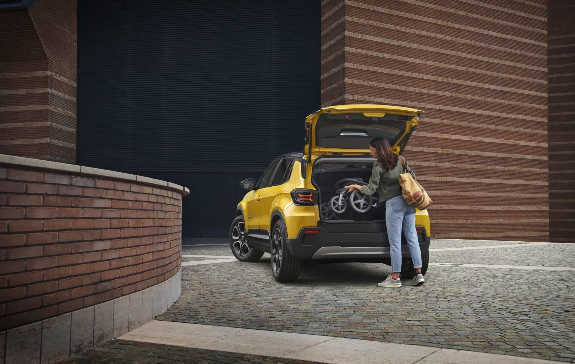 Vista de tres cuartos trasera del Jeep Avenger iluminado en ambiente urbano