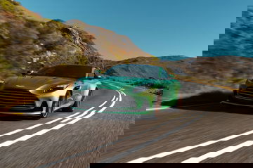 Aston Martin DB12 captado en pleno dinamismo en carretera de montaña.