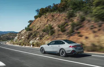 BMW Serie 5 en pleno dinamismo, capturado en una carretera con curvas.