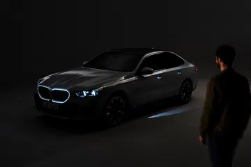 Vista nocturna de un BMW Serie 5, resaltando su iluminación frontal y diseño lateral.