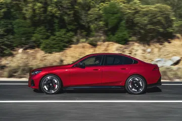 Vista lateral de un BMW Serie 5 en color rojo, destacando su diseño aerodinámico.