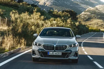 Vista frontal del BMW Serie 5 en carretera, destacando su imponente parrilla.