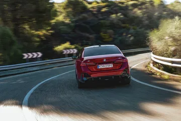 Vista trasera de un BMW Serie 5 en movimiento, destacando su diseño y prestaciones.