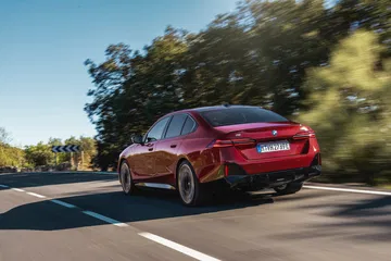 BMW Serie 5 en una carretera, destacando su perfil lateral y diseño dinámico.