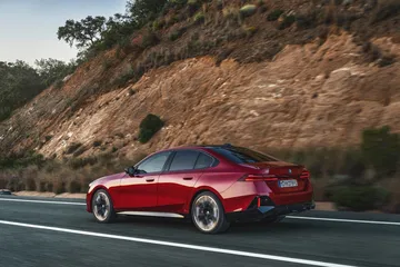 Vista dinámica del BMW Serie 5 en carretera, destacando su línea lateral.