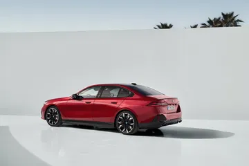 Vista lateral que muestra el dinamismo y diseño del BMW Serie 5 en color rojo.