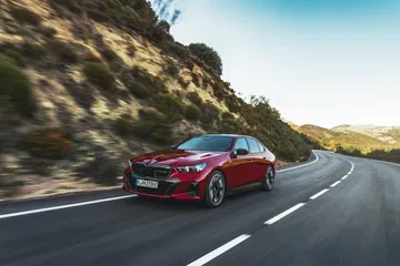 Vista dinámica del BMW Serie 5 rojo en carretera abierta.