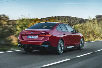 Vista dinámica de la trasera y lateral de un BMW Serie 5 en movimiento.