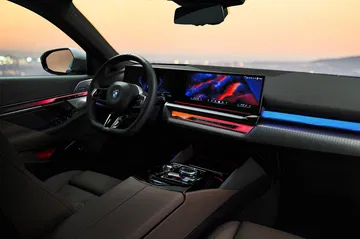 Vista nocturna del tablero y volante iluminados del BMW Serie 5.