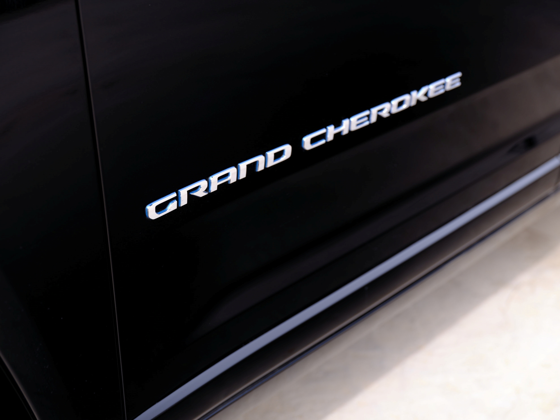 Vista cercana del emblema 'Grand Cherokee' en el lateral del vehículo.