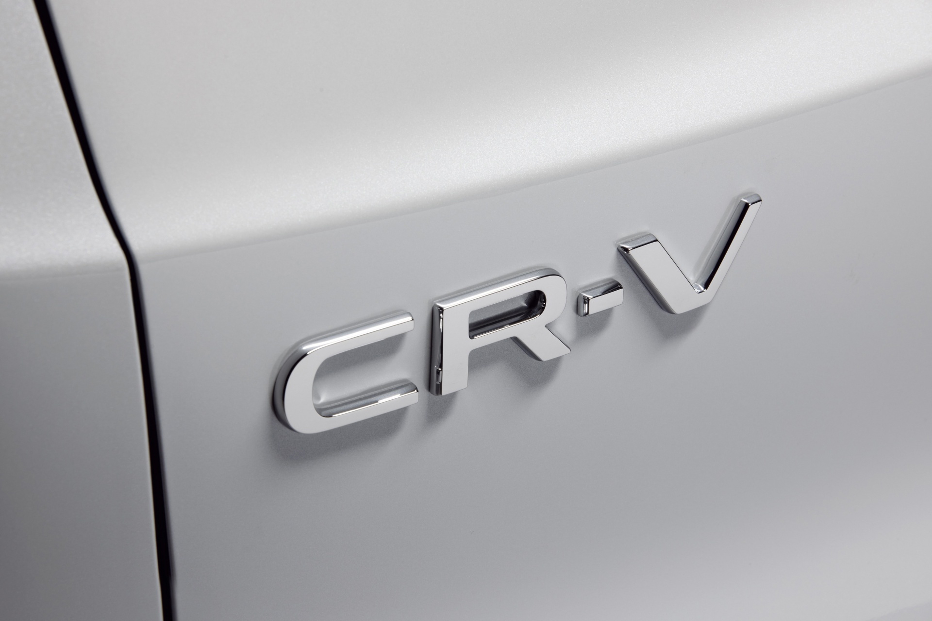 Vista cercana del emblema Honda CR-V en relieve sobre la carrocería.