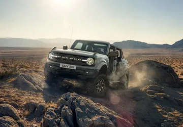 Ford Bronco superando obstáculos en terreno rocoso, demostrando su capacidad todoterreno.