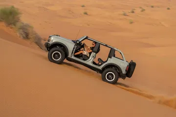 Vista aérea del Ford Bronco superando dunas áridas.