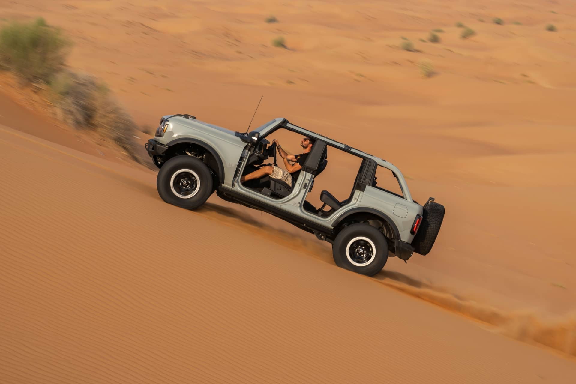 Vista aérea del Ford Bronco superando dunas áridas.