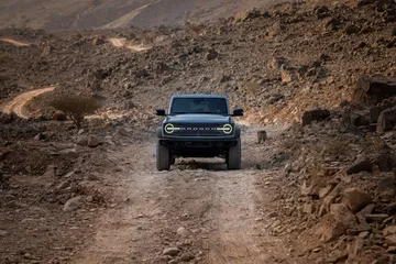 Ford Bronco afrontando un terreno rocoso, demostrando sus capacidades todoterreno.