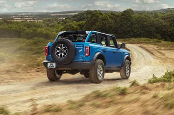 Vista dinámica del Ford Bronco superando terreno irregular.