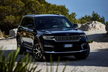 Imagen frontal lateral del Jeep Grand Cherokee, mostrando su robustez y diseño elegante.