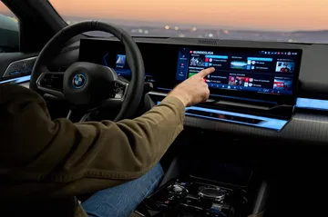 Vista del sistema de infotainment con la mano del usuario seleccionando opciones.