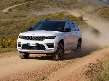 Vista dinámica del Jeep Grand Cherokee atravesando terreno irregular.