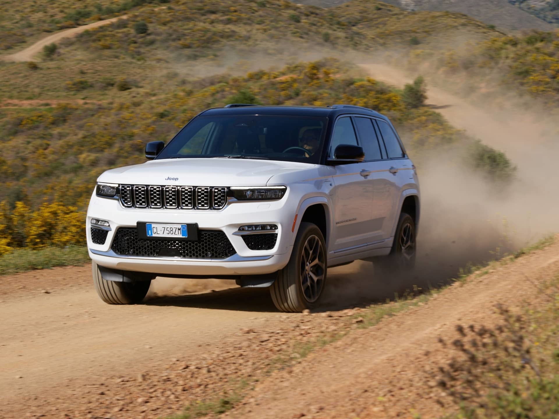 Vista dinámica del Jeep Grand Cherokee atravesando terreno irregular.