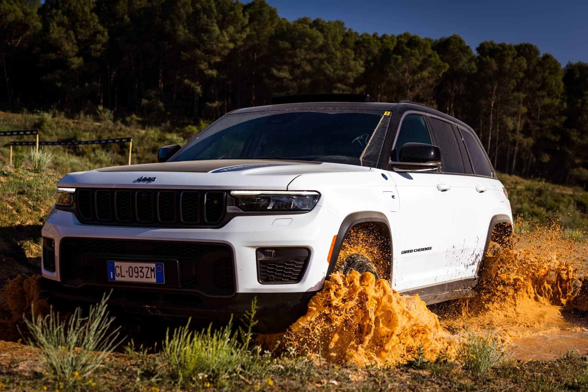 Vista lateral y frontal del Jeep Grand Cherokee en terreno agreste