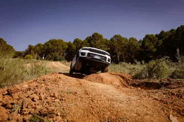 Imagen capturando el Jeep Grand Cherokee en acción sobre terreno irregular.