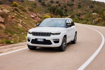 Vista dinámica del Jeep Grand Cherokee, destacando su frontal y línea lateral.