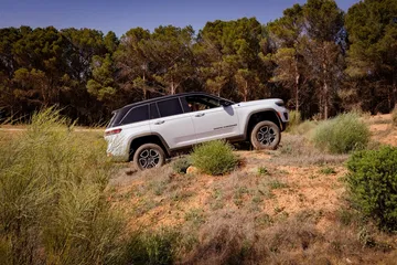 Vista lateral del Jeep Grand Cherokee superando un desafío off-road.