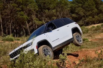Vista lateral del Jeep Grand Cherokee superando un terreno inclinado